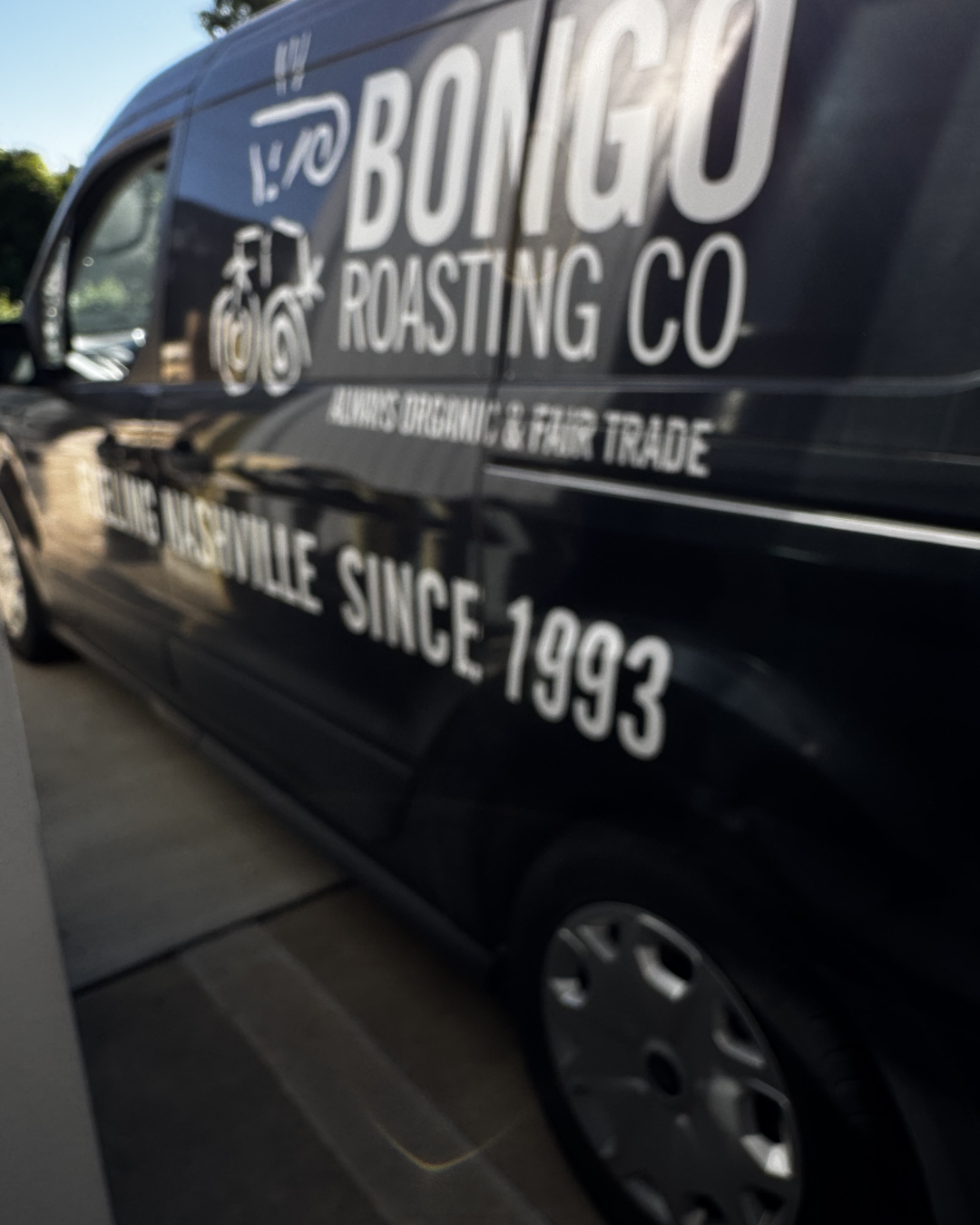 Black van with 'Bonigou Roasting Co' branding on a road.